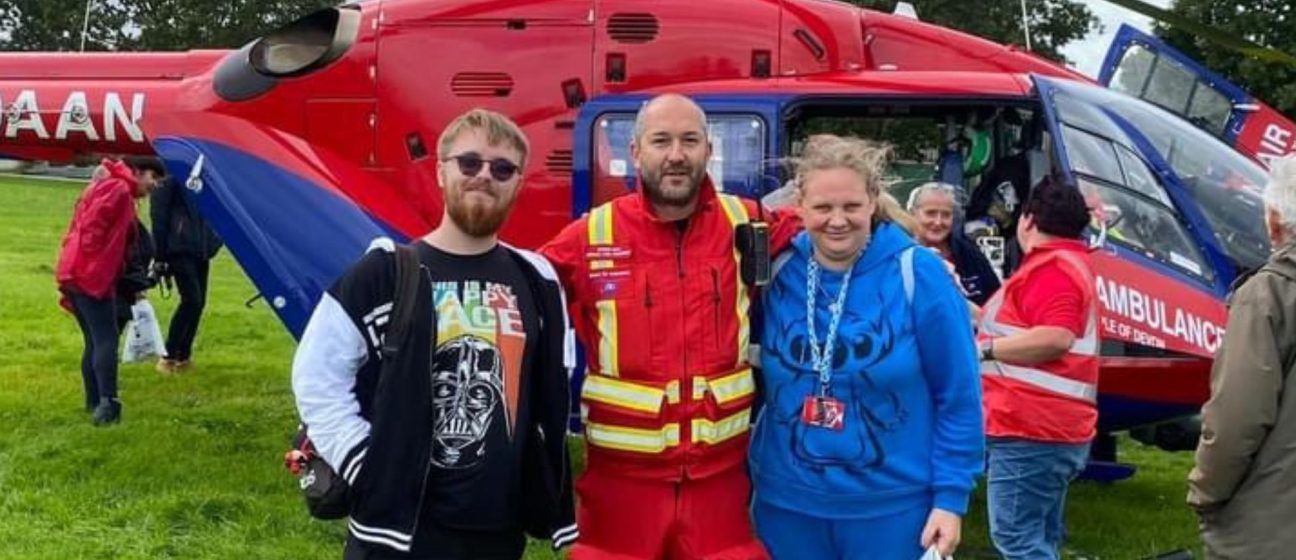 Volunteers with a crew member next to our helicopter