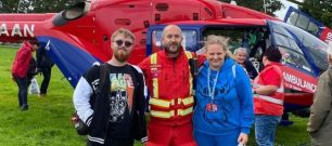 Volunteers with a crew member next to our helicopter