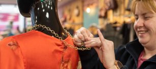 Retail volunteer dressing a mannequin